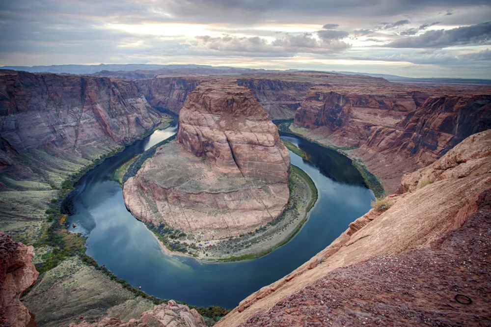 A broad bend in the Colorado River beneath sandstone cliffs